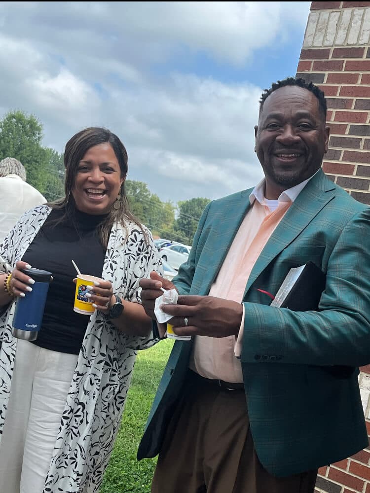 Two smiling guests enjoying Community Day together outside the church