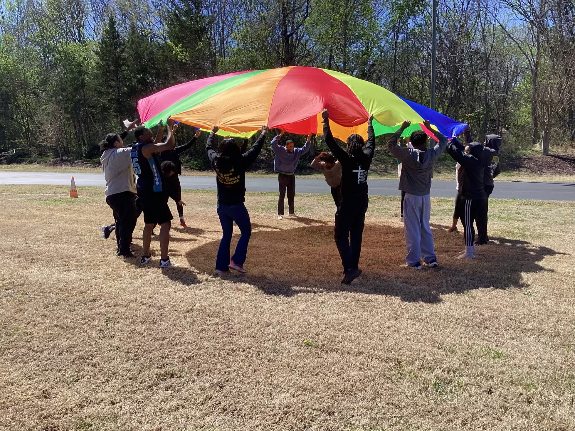 A group playing a parachute game on the church lawn