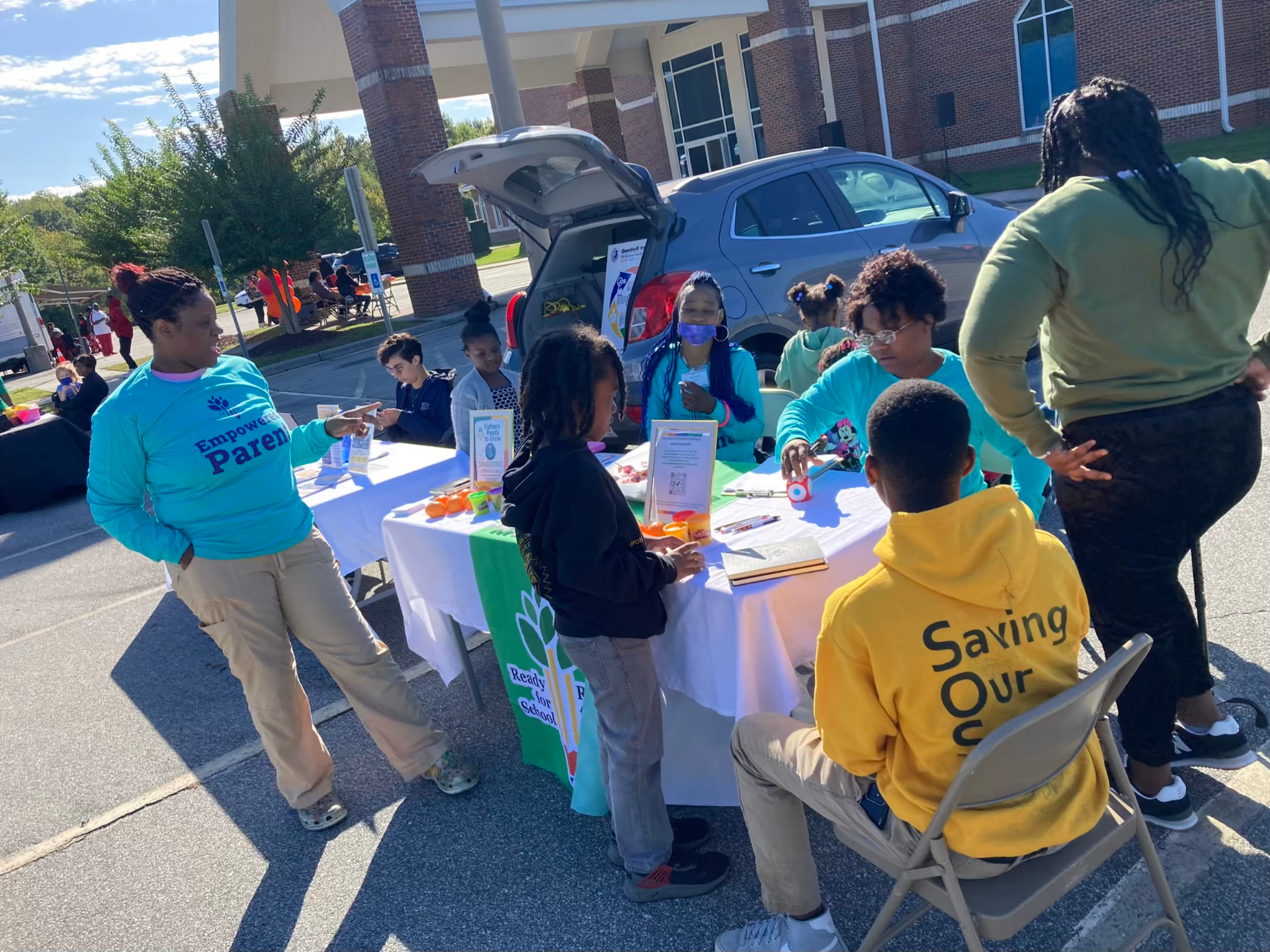 Kids visiting a family-resource vendor table at Community Day